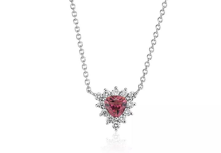 A trillion-cut pink tourmaline gemstone pendant surrounded by a halo of round-cut diamonds in white gold.